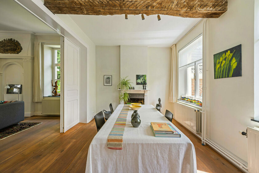 gesepareerd door stijlvolle houten deuren. Links van de hal is er een aangename zithoek en een moderne leefkeuken (2012), compleet uitgerust met kwalitatieve apparatuur. Verder is er een hal die leidt naar de berging en de linker aanbouw. Toilet. 1e VERDI