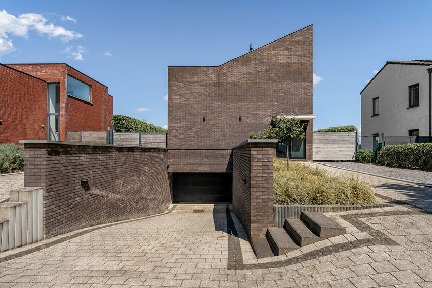 dankzij de grote tuingerichte raampartijen (Schüco). Ruime berging / wasplaats, opp. 12,4 m². VERDIEPING 1 > Nachthal. Masterbedroom van 21,32 m² met een bijzonder mooi uitzicht op de landelijke omgeving. Het hoge plafond tot in de nok van het dak maak