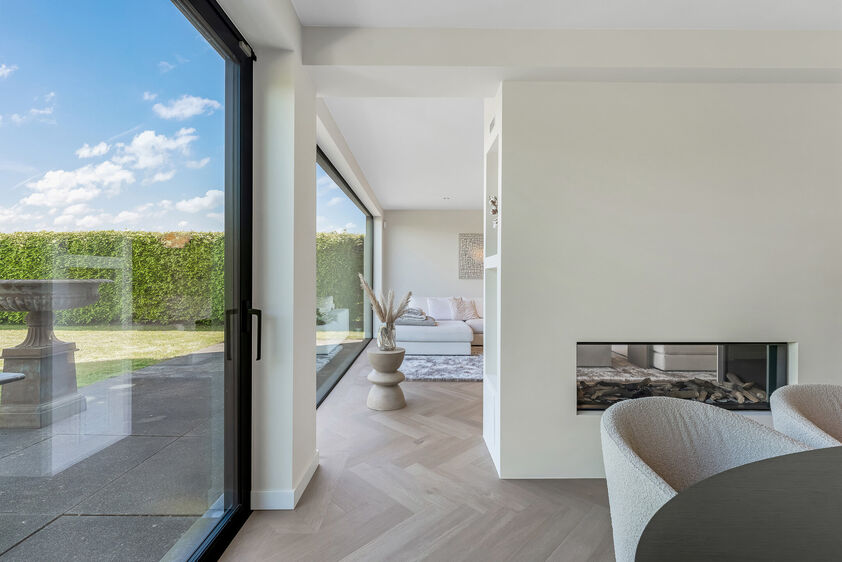 dankzij de grote tuingerichte raampartijen (Schüco). Ruime berging / wasplaats, opp. 12,4 m². VERDIEPING 1 > Nachthal. Masterbedroom van 21,32 m² met een bijzonder mooi uitzicht op de landelijke omgeving. Het hoge plafond tot in de nok van het dak maak