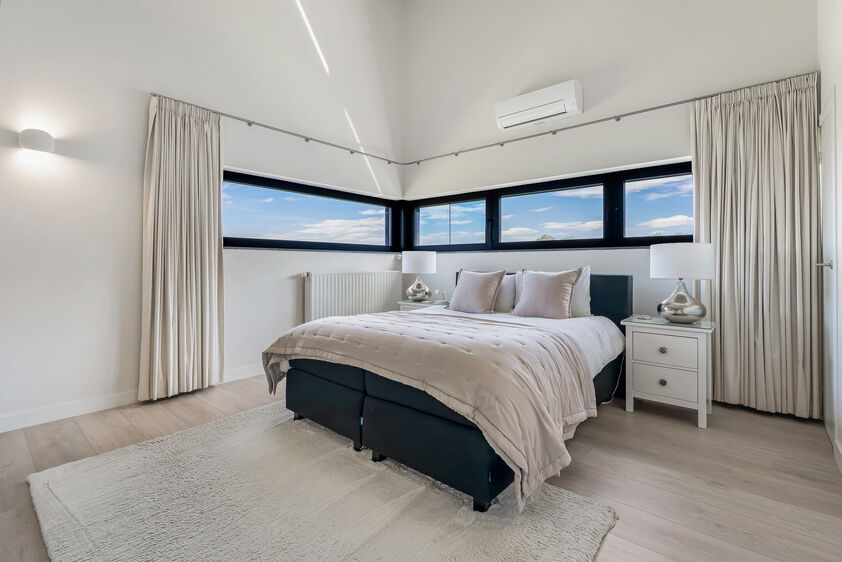 dankzij de grote tuingerichte raampartijen (Schüco). Ruime berging / wasplaats, opp. 12,4 m². VERDIEPING 1 > Nachthal. Masterbedroom van 21,32 m² met een bijzonder mooi uitzicht op de landelijke omgeving. Het hoge plafond tot in de nok van het dak maak