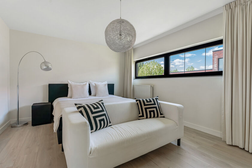 dankzij de grote tuingerichte raampartijen (Schüco). Ruime berging / wasplaats, opp. 12,4 m². VERDIEPING 1 > Nachthal. Masterbedroom van 21,32 m² met een bijzonder mooi uitzicht op de landelijke omgeving. Het hoge plafond tot in de nok van het dak maak