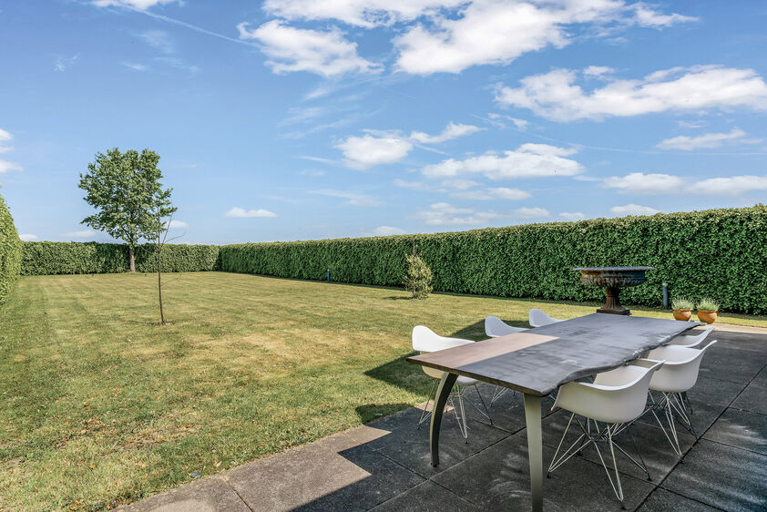 dankzij de grote tuingerichte raampartijen (Schüco). Ruime berging / wasplaats, opp. 12,4 m². VERDIEPING 1 > Nachthal. Masterbedroom van 21,32 m² met een bijzonder mooi uitzicht op de landelijke omgeving. Het hoge plafond tot in de nok van het dak maak