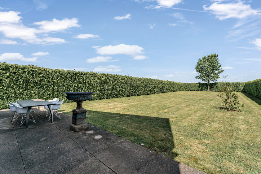 dankzij de grote tuingerichte raampartijen (Schüco). Ruime berging / wasplaats, opp. 12,4 m². VERDIEPING 1 > Nachthal. Masterbedroom van 21,32 m² met een bijzonder mooi uitzicht op de landelijke omgeving. Het hoge plafond tot in de nok van het dak maak