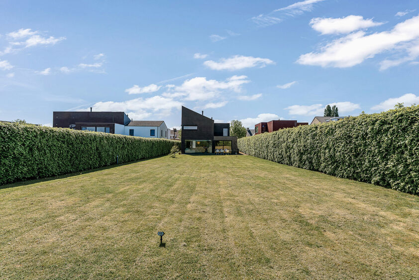 dankzij de grote tuingerichte raampartijen (Schüco). Ruime berging / wasplaats, opp. 12,4 m². VERDIEPING 1 > Nachthal. Masterbedroom van 21,32 m² met een bijzonder mooi uitzicht op de landelijke omgeving. Het hoge plafond tot in de nok van het dak maak