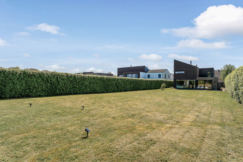 dankzij de grote tuingerichte raampartijen (Schüco). Ruime berging / wasplaats, opp. 12,4 m². VERDIEPING 1 > Nachthal. Masterbedroom van 21,32 m² met een bijzonder mooi uitzicht op de landelijke omgeving. Het hoge plafond tot in de nok van het dak maak