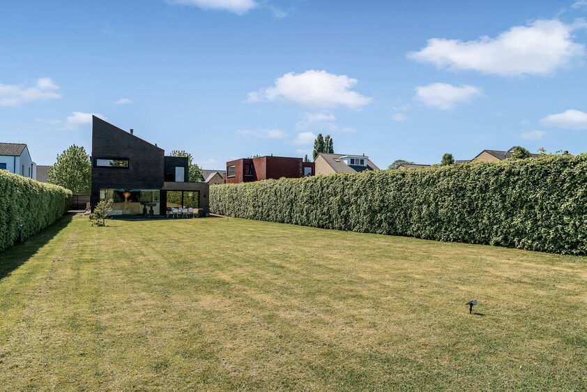 dankzij de grote tuingerichte raampartijen (Schüco). Ruime berging / wasplaats, opp. 12,4 m². VERDIEPING 1 > Nachthal. Masterbedroom van 21,32 m² met een bijzonder mooi uitzicht op de landelijke omgeving. Het hoge plafond tot in de nok van het dak maak