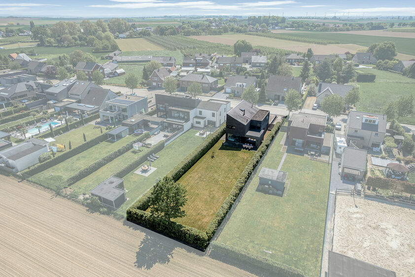 dankzij de grote tuingerichte raampartijen (Schüco). Ruime berging / wasplaats, opp. 12,4 m². VERDIEPING 1 > Nachthal. Masterbedroom van 21,32 m² met een bijzonder mooi uitzicht op de landelijke omgeving. Het hoge plafond tot in de nok van het dak maak