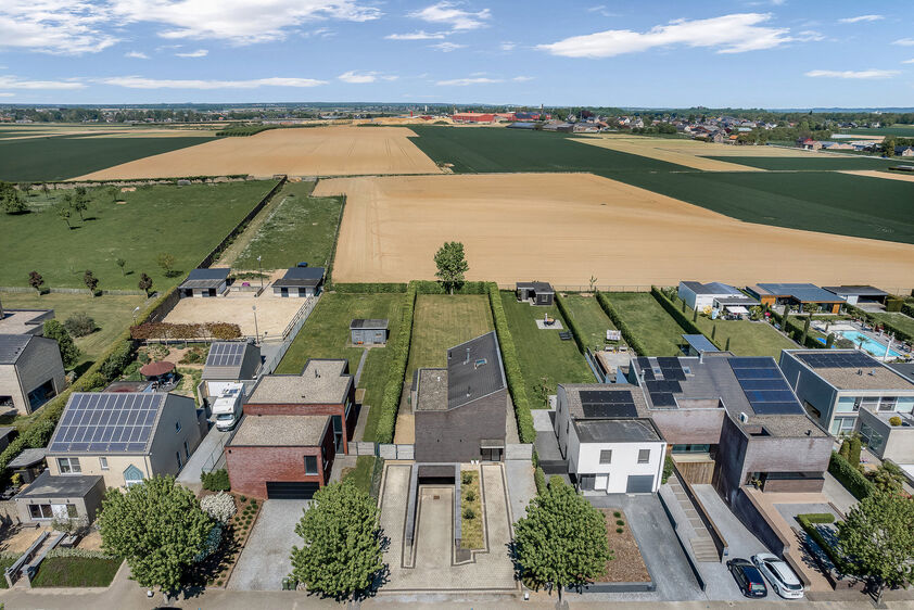 dankzij de grote tuingerichte raampartijen (Schüco). Ruime berging / wasplaats, opp. 12,4 m². VERDIEPING 1 > Nachthal. Masterbedroom van 21,32 m² met een bijzonder mooi uitzicht op de landelijke omgeving. Het hoge plafond tot in de nok van het dak maak